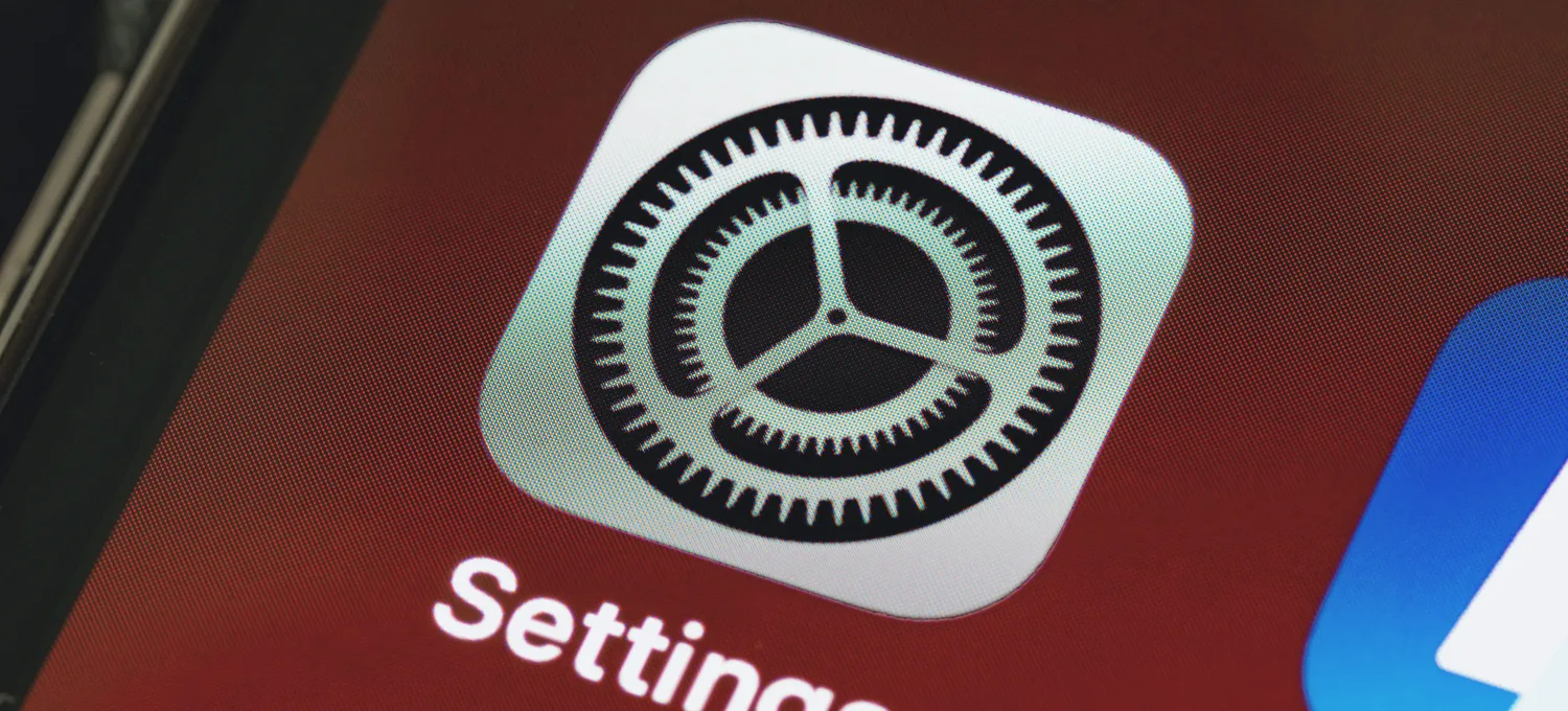 An iPhone screen, hand holding it at angle, soft daylight
